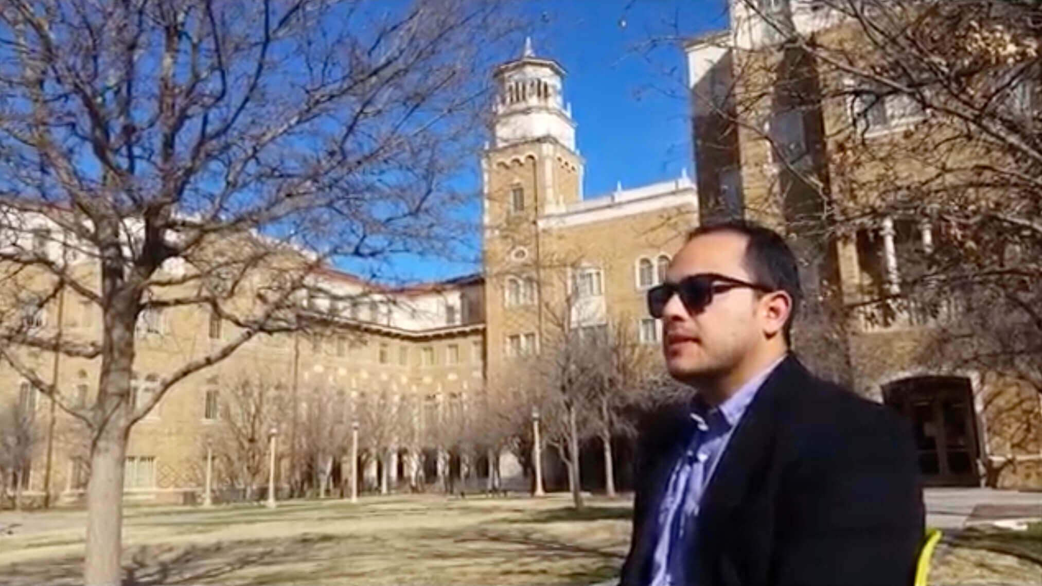 Ruben Varona sentado afuera de un edificio en un día soleado