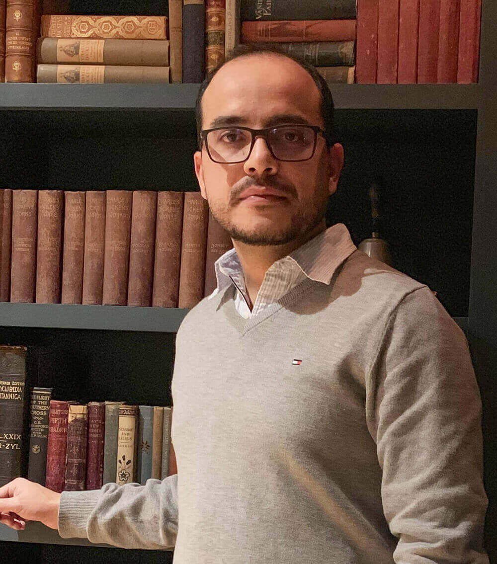 Ruben Varona posando al lado de una biblioteca